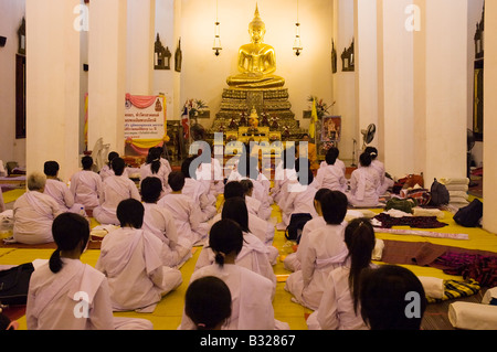 Moniales novices méditer en rangées à l'intérieur d'un Thai Buddist Temple avec une statue de Bouddha. Wat Pho, Bangkok Banque D'Images