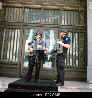 Les policiers américains armés du NYPD flic flip avec la police et les drapeaux américains devant la Bourse de New York sur Wall Street à New York City NYC USA KATHY DEWITT Banque D'Images