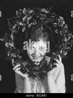 Portrait of woman holding Christmas wreath Banque D'Images