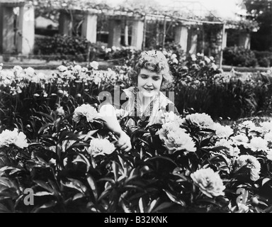 Woman tending flowers in garden Banque D'Images