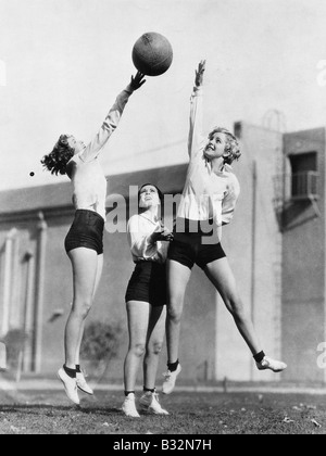 Trois femmes avec le basket-ball dans l'air Banque D'Images