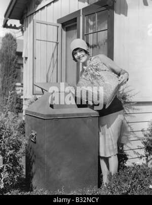 Portrait of woman taking out trash Banque D'Images