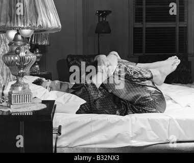 Woman stretching on bed Banque D'Images