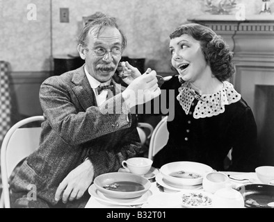 Portrait d'une femme et un homme à l'autre soupe d'alimentation à une table Banque D'Images