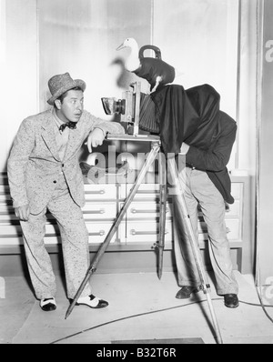 Photographe de prendre une photo d'un jeune homme Banque D'Images