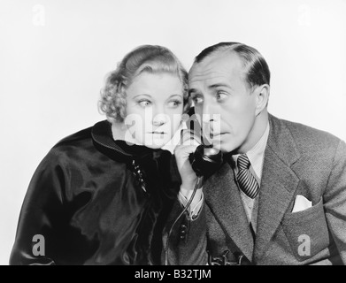 Homme et une femme écoute le téléphone Banque D'Images