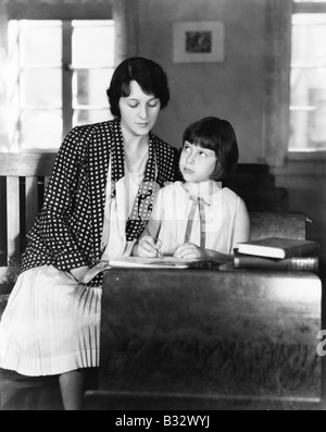 Fille assise avec son professeur dans une salle de classe Banque D'Images