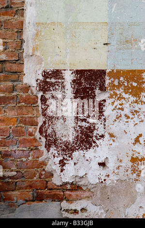 Peinture écaillée et du ciment sur le côté du mur de briques Banque D'Images