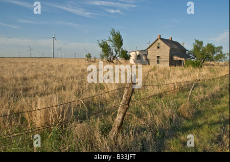 Texas Panhandle Plains ranch abandonné près de bâtiment de production d'électricité des éoliennes modernes Banque D'Images