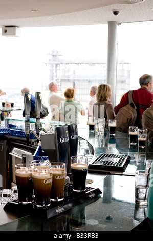 Pintes de Guinness versé dans la circulaire bar Gravity au sommet de la Guinness Storehouse à Dublin dans la brasserie Banque D'Images