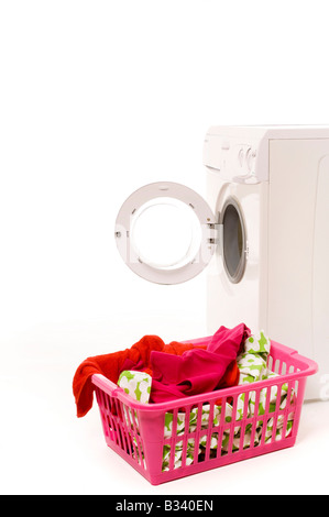 Lave-linge automatique domestique sur fond blanc vue latérale avec porte ouverte et panier de lavage en plastique rose plein de linge au premier plan. Banque D'Images