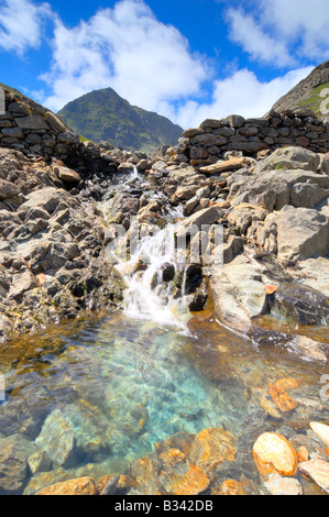 Chute se déversant entre Llyn Llyn Llydaw Glaslyn et à côté de la piste des mineurs route vers le sommet du Mont Snowdon Banque D'Images