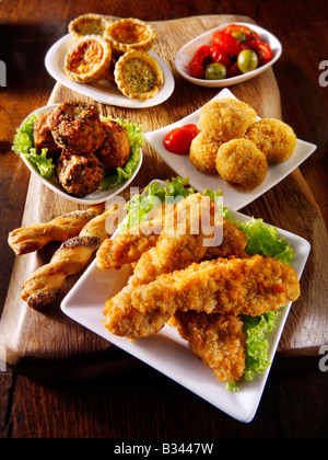 Cuisine de fête - de l'avant - goujons panés de poulet, fromage, oignon, mini-quicehe bhajis et sunblushed tomates et olives. Banque D'Images