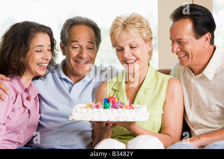 Deux couples dans la salle de séjour avec gâteau smiling Banque D'Images