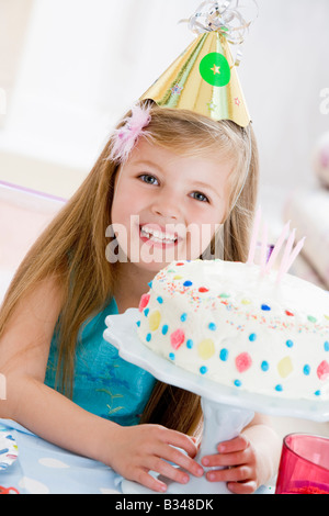 Young Girl wearing party hat avec gâteau d'anniversaire, smiling Banque D'Images