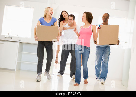 Groupe d'amis moving into new home smiling Banque D'Images