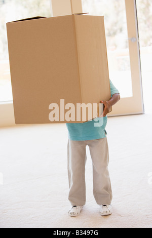 Young boy holding box in new home Banque D'Images