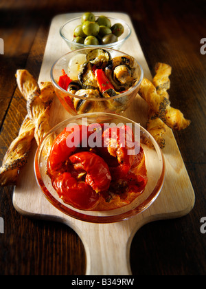 Antipasti - sun rougit les tomates, champignons et légumes et olives avec bâtonnets de pain. Banque D'Images