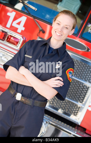 Firewoman standing in front of fire engine Banque D'Images