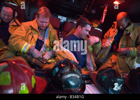 Quatre pompiers de pompiers mettre sur le pignon (FLOU) Banque D'Images