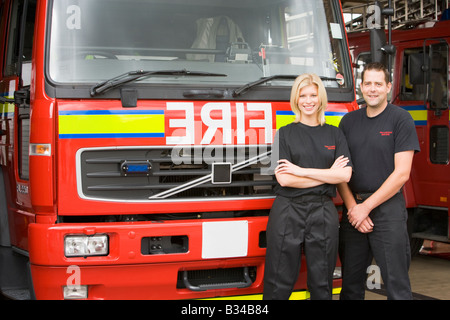 Deux pompiers standing in front of fire engine Banque D'Images