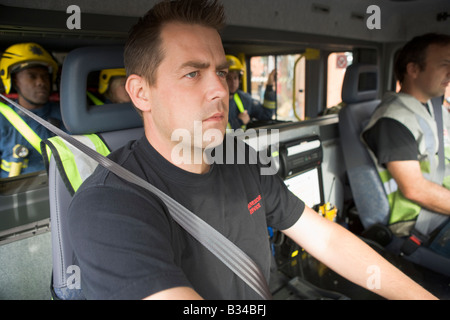 Groupe de pompiers dans un incendie moteur avec l'accent sur le siège passager (selective focus) Banque D'Images