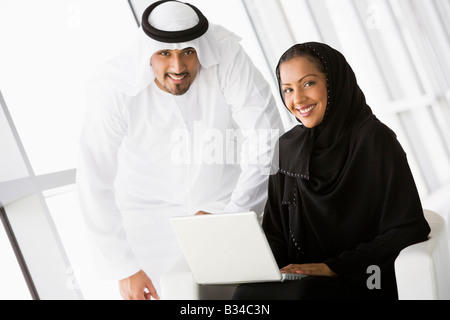 Deux personnes à l'intérieur avec laptop smiling (high key/focus sélectif) Banque D'Images