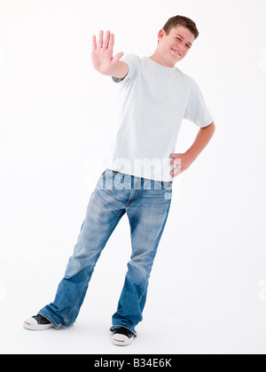 Teenage boy standing with hand up Banque D'Images