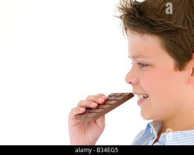 Young boy eating chocolate bar Banque D'Images