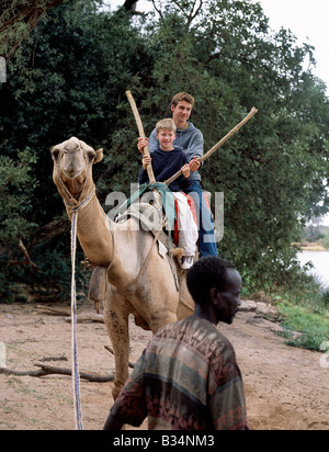 Kenya, Samburu, Samburu National Reserve. Deux jeunes touristes profitez d'un tour de chameau dans la réserve nationale de Samburu. Banque D'Images