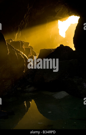 Un arbre de lumière au coucher du soleil chaud se déverse à travers une arche à Big Sur, Pfeiffer Beach Banque D'Images