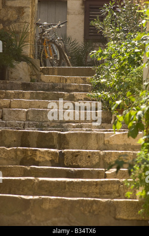 Les vélos en haut de l'escalier de pierre dans les ruelles de Hvar Croatie Banque D'Images