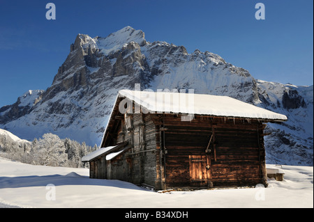 Des alpages avec un chalet en hiver avec le Wetterhorn derrière - Swiss Alpes Brenese Banque D'Images