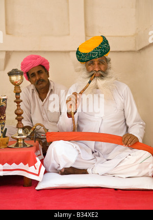 Un agent homme Rajasthani démontre l'utilisation d'un narguilé tuyau dans le MEHERANGARH FORT JOHDPUR RAJASTHAN INDE Banque D'Images