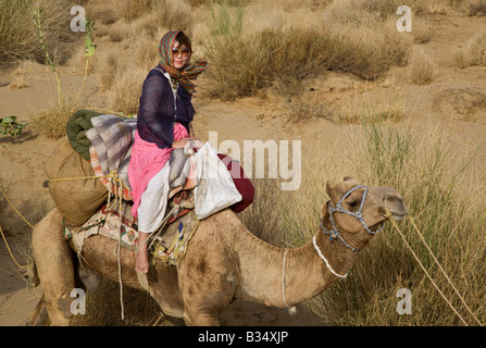 Une JAPONAISE monte un chameau dans le désert de Thar lors d'un SAFARI près de Jaisalmer RAJASTHAN INDE M. Banque D'Images