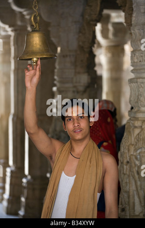 JAIN PRÊTRE sonne une cloche à l'intérieur du MANDIR CHAUMUKHA TEMPLE DE RANAKPUR dans le district de Pali RAJASTHAN INDE près de Sadri Banque D'Images