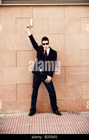 Homme armé en posant des lunettes de fantaisie Banque D'Images