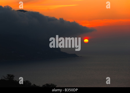 Un coucher de soleil pittoresque avec de magnifiques montagnes sous brouillard Banque D'Images