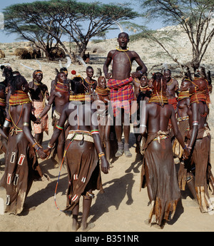 Kenya, Turkana, Nachola. Chanson est une forme d'art enraciné dans la culture Turkana. À la fin d'une session de danse, les participants bénéficient invariablement la chanson des taureaux. Chaque jeune homme va prendre le devant de la scène pour chanter les louanges de son bœuf. Il expliquera comment il est entré en sa possession, ses traits distinctifs et avec les bras tendus, imitent la forme de ses cornes. Banque D'Images