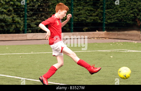 Garçon de 11 ans à jouer au football, Maida Vale, à Londres, Royaume-Uni. Banque D'Images