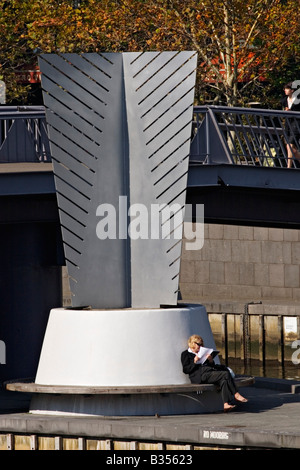 Les gens de Melbourne / une femme est assise et lit en dessous de la "passerelle" Yarra de Melbourne Victoria en Australie. Banque D'Images