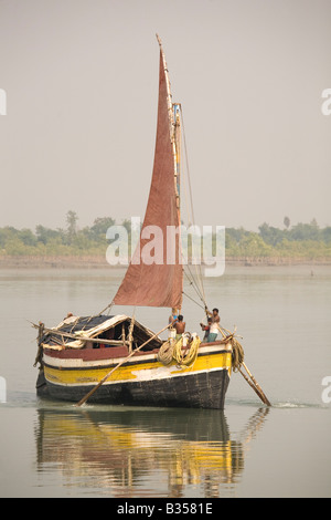 Un bateau style indésirable est ramé sur le delta du Gange dans les Sunderbans National Park dans l'ouest du Bengale, en Inde. Banque D'Images