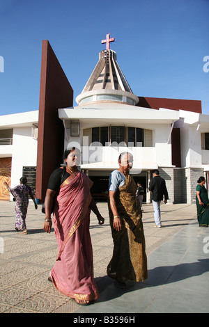 Deux femmes passent devant l'église de style moderne de l'Enfant Jésus à Bangalore, Inde. Banque D'Images
