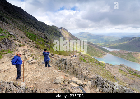 Deux personnes se reposer et admirer la vue depuis la piste vers Pyg Llyn Llyn Llydaw Glaslyn et sur le mont Snowdon Banque D'Images