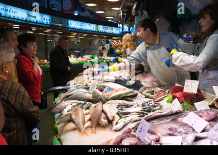 Espagne Barcelone poissonniers montrent le poisson frais à des clients au marché de la Boqueria produire plusieurs variétés sur l'affichage Banque D'Images