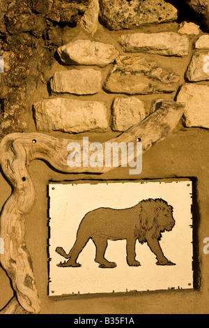 Logo sur mur de pierre par cabines climatisées de lion pour Okaukuejo Namibie un Wildlife Resort Lodge dans le parc d'Etosha Banque D'Images