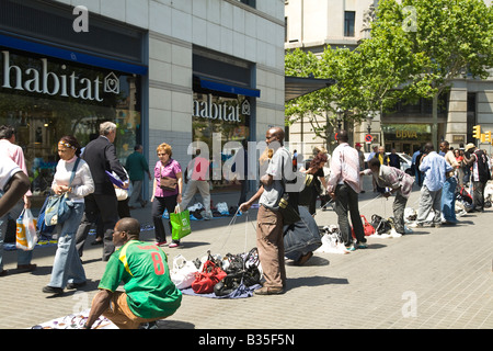 Espagne Barcelone les vendeurs de rue de l'imitation et de faux compromis rip articles restent sur le trottoir à pied par les clients prêts à plier Banque D'Images