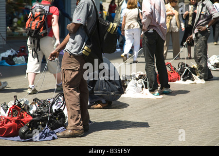 Espagne Barcelone les vendeurs de rue de l'imitation et de faux compromis rip articles restent sur le trottoir à pied par les clients prêts à plier Banque D'Images