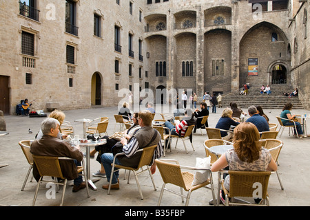 Espagne Barcelone Des couples s'asseoir à table tandis que les femmes jouant de la guitare acoustique en Plaça del Rei plaza King s Square Banque D'Images