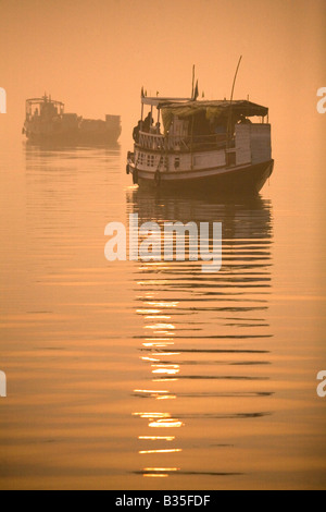 Deux bateaux sur le delta du Gange dans le parc national des Sunderbans du Bengale occidental, en Inde. Le soleil se lève sur l'eau. Banque D'Images